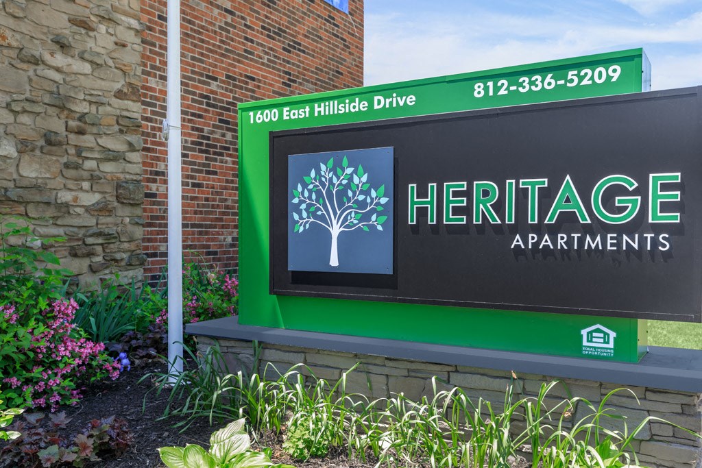 a sign for heritage apartments on the side of a building