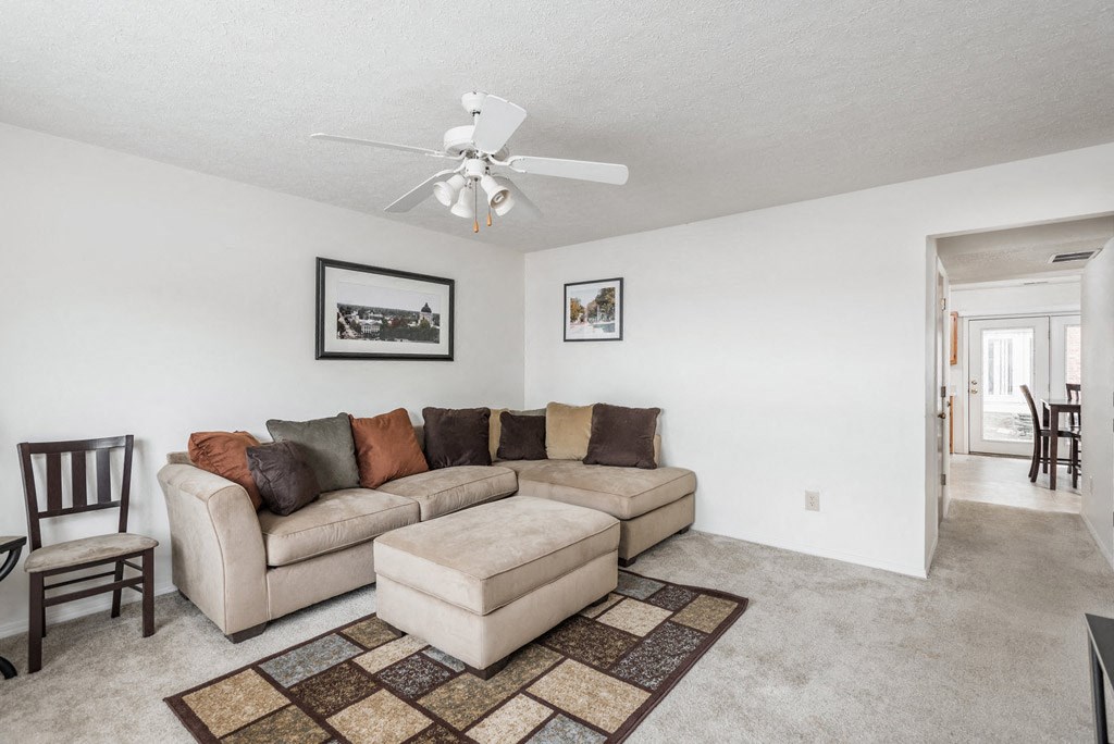 a living room with a couch and a ceiling fan