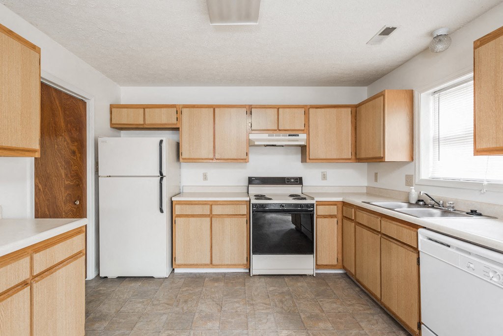 a kitchen with white appliances and wooden cabinets
