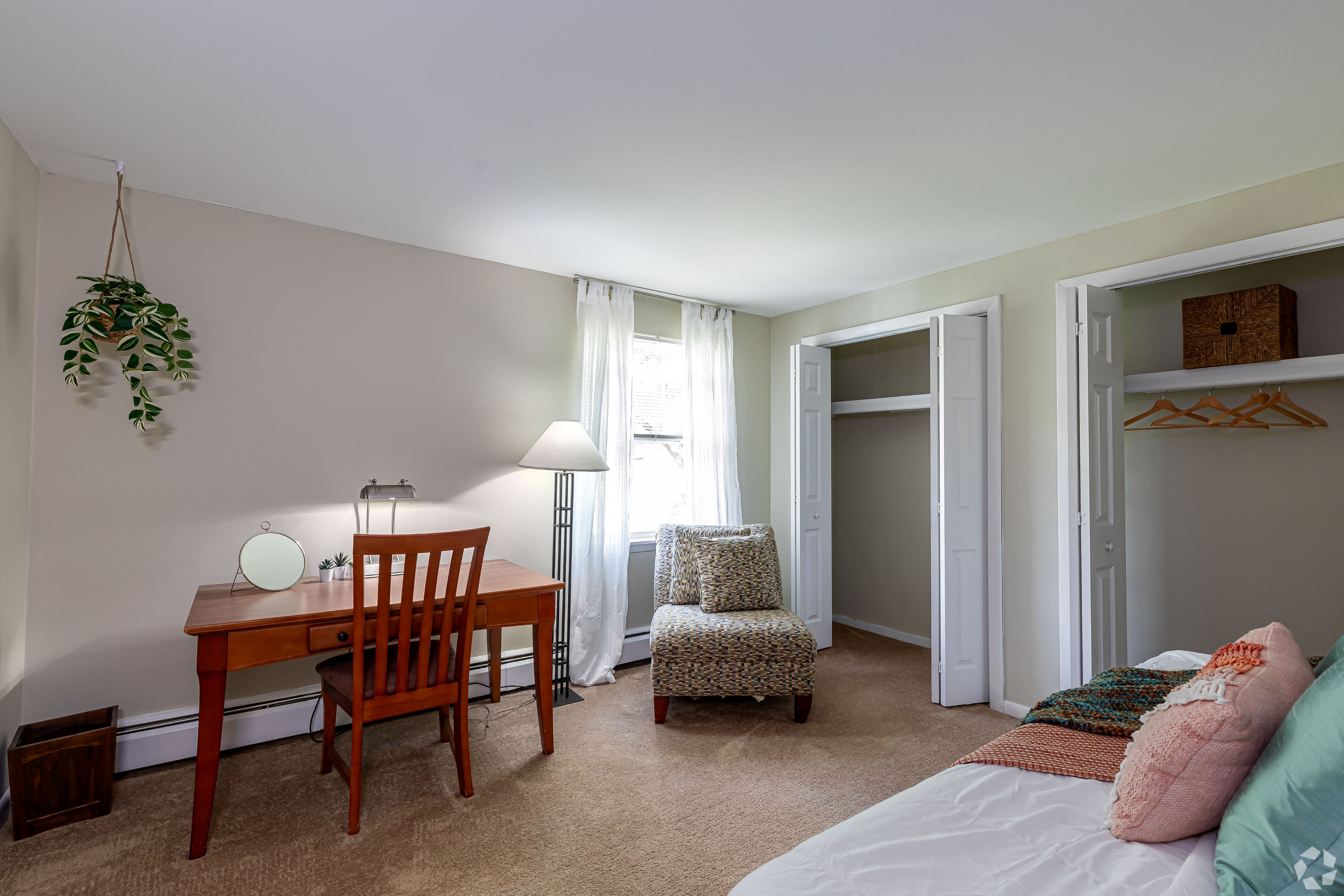 a bedroom with a bed and a desk with a chair