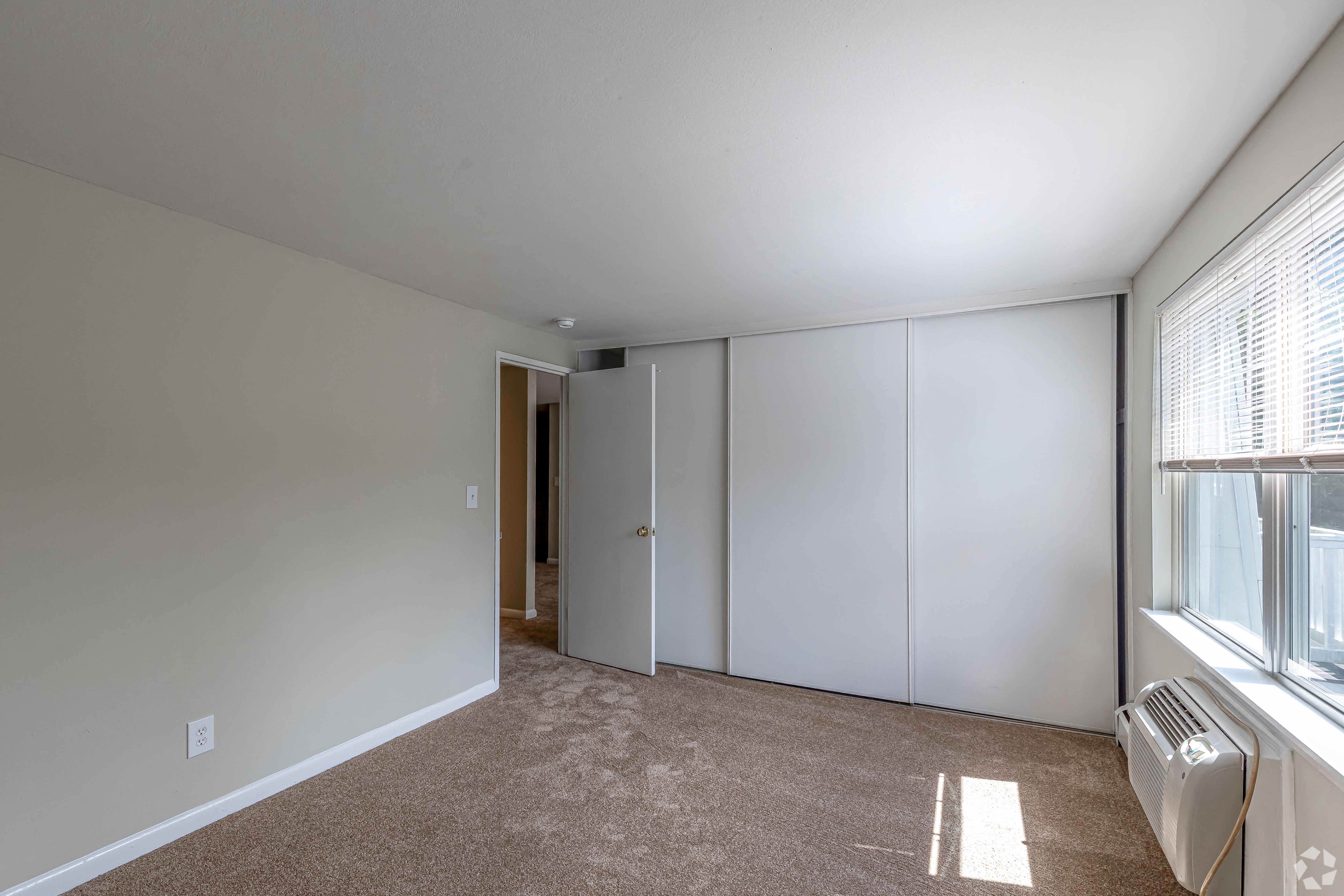 an empty living room with white walls and a window
