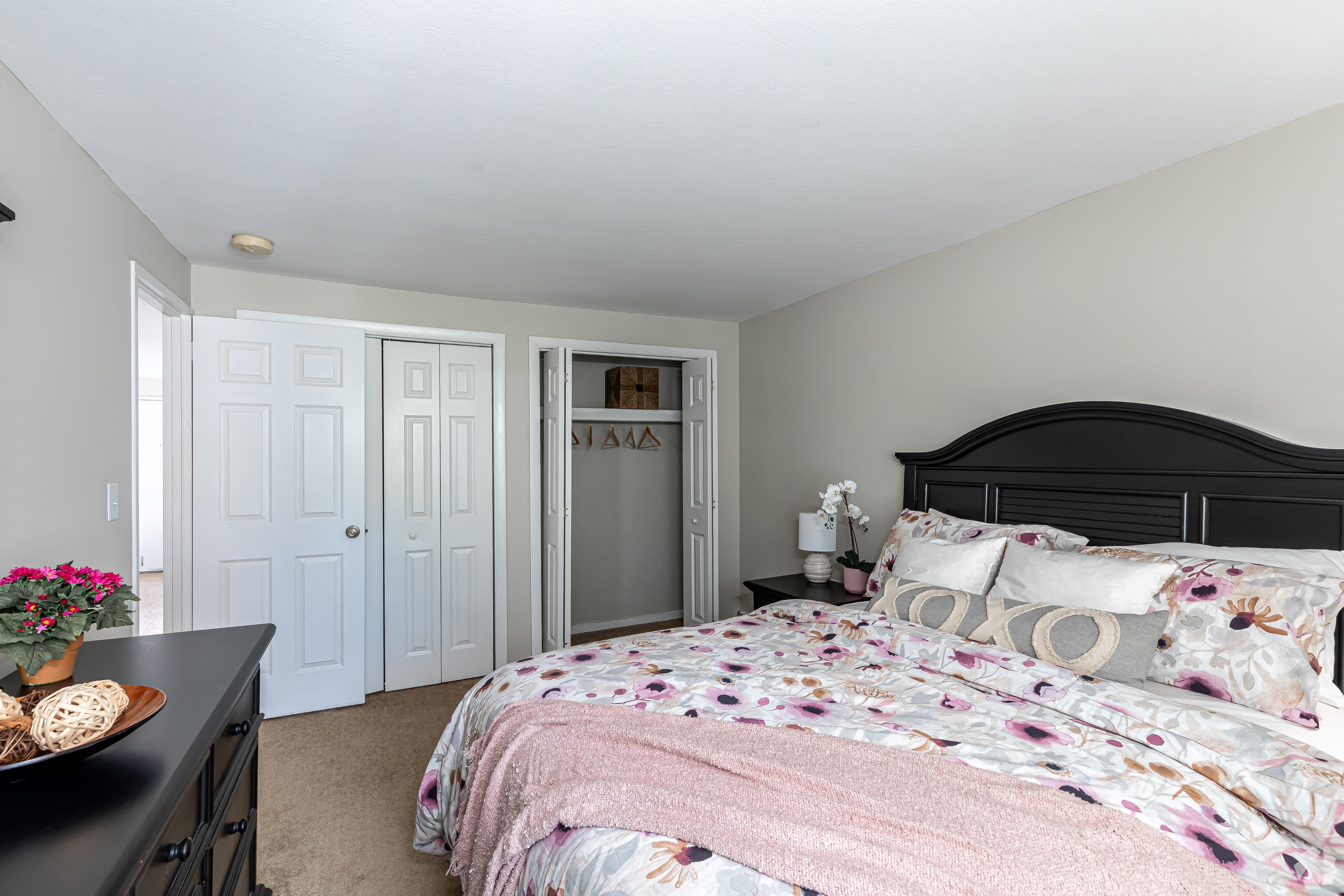 a bedroom with a bed and a dresser and a closet