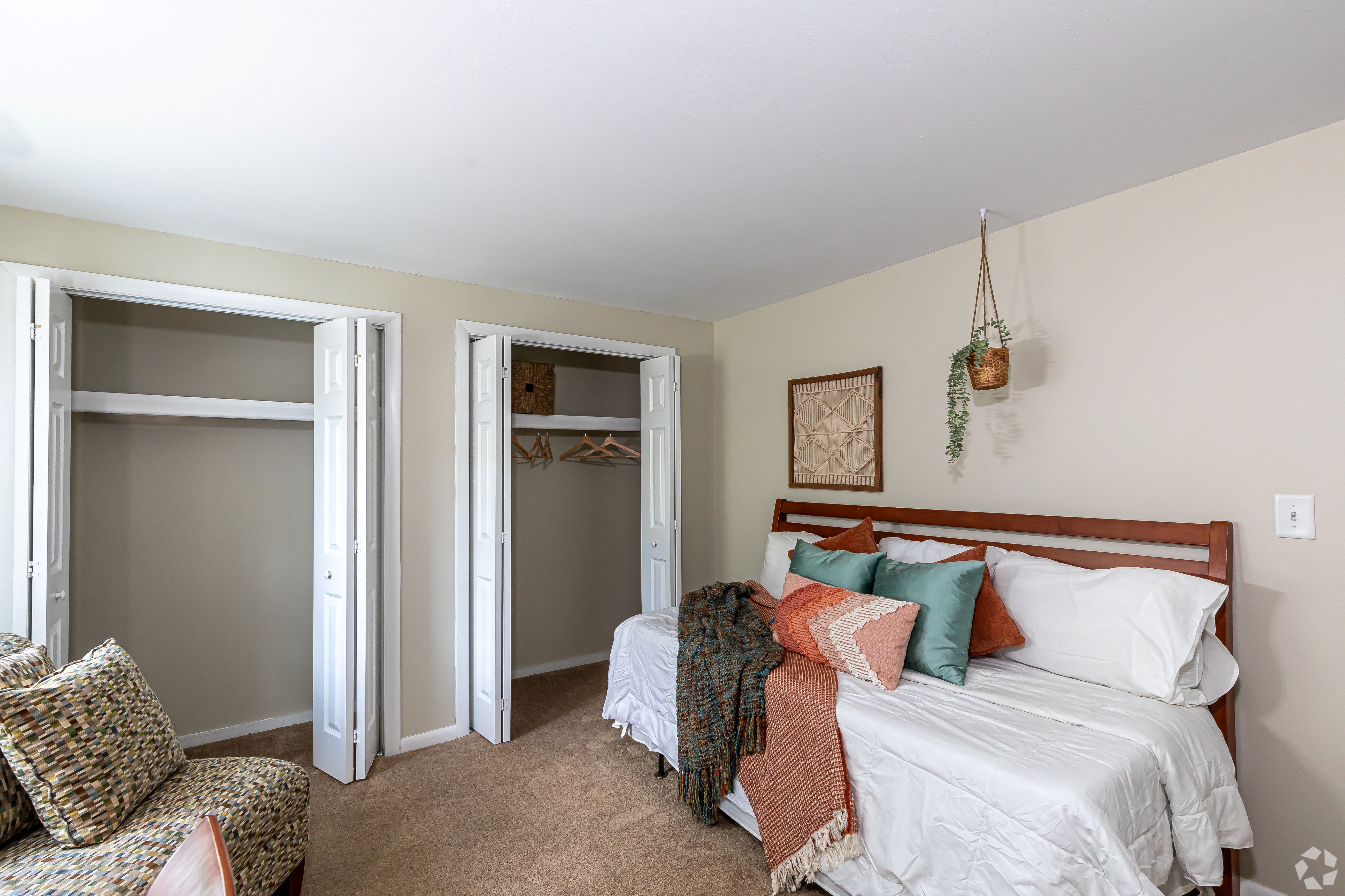 a bedroom with a bed and a chair and a closet