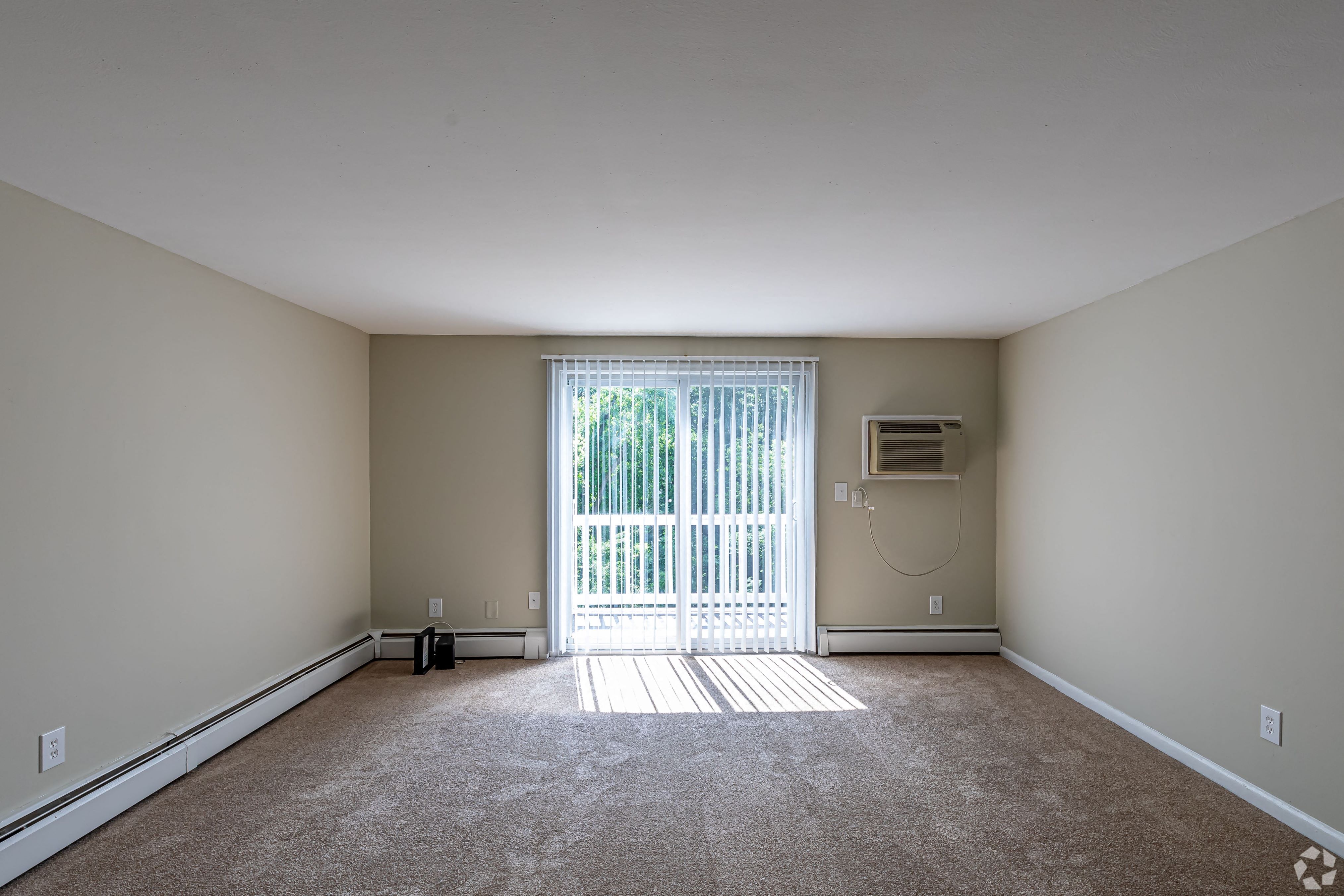 an empty room with a sliding glass door and a window