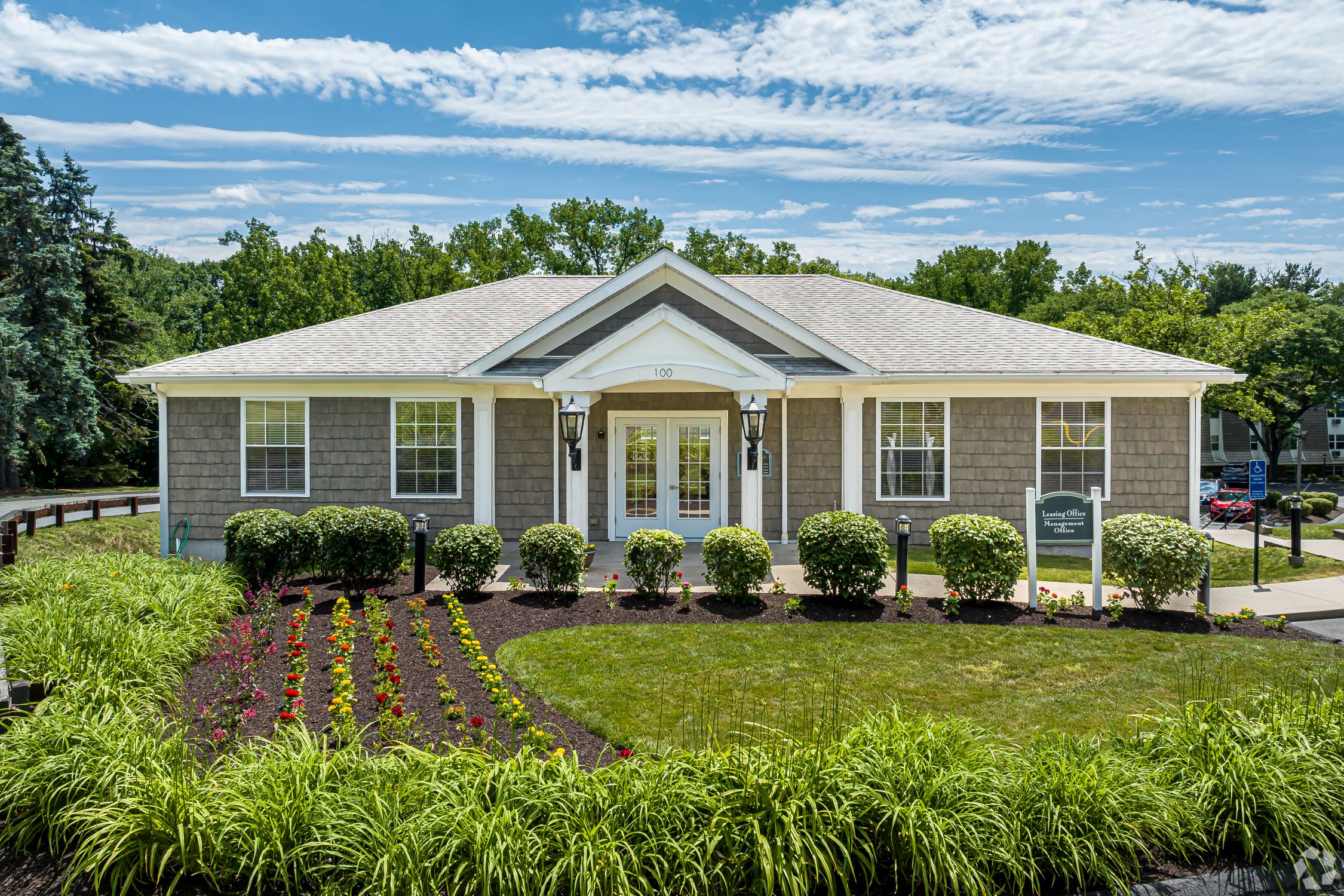 the front of a house with a lawn and flowers