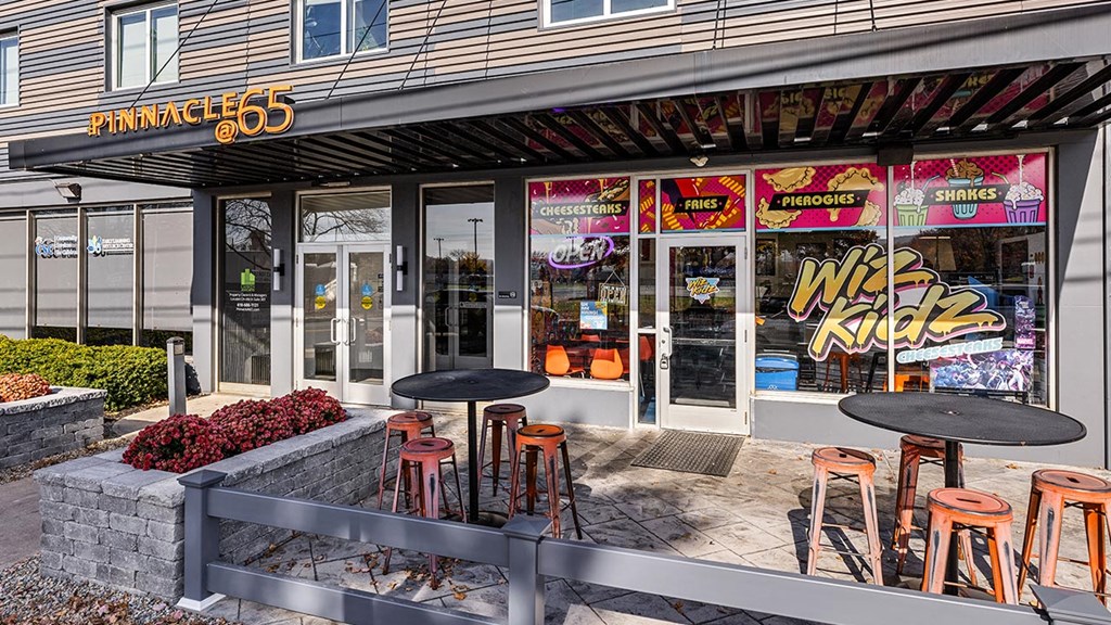 a big kick bar with tables and chairs outside of a building