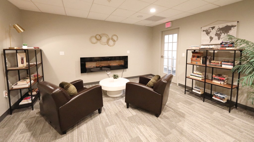 a living room with leather chairs and a fireplace
