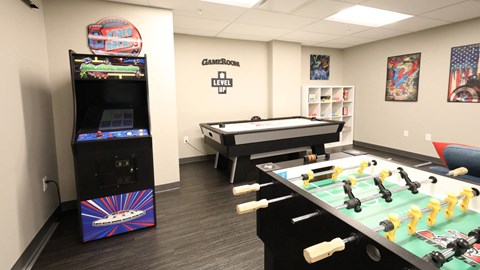 a game room with a pool table and video games