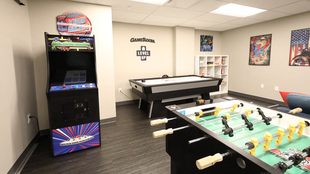 a game room with a pool table and video games