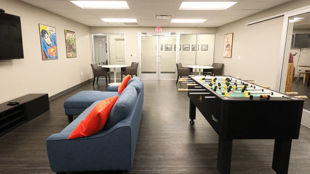 a game room with a foosball table and chairs