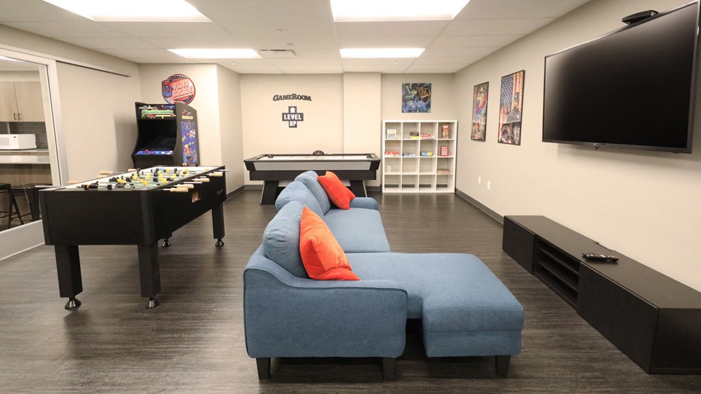 a game room with a foosball table and a flat screen tv