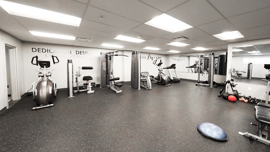 a workout room with weights and cardio equipment in a building
