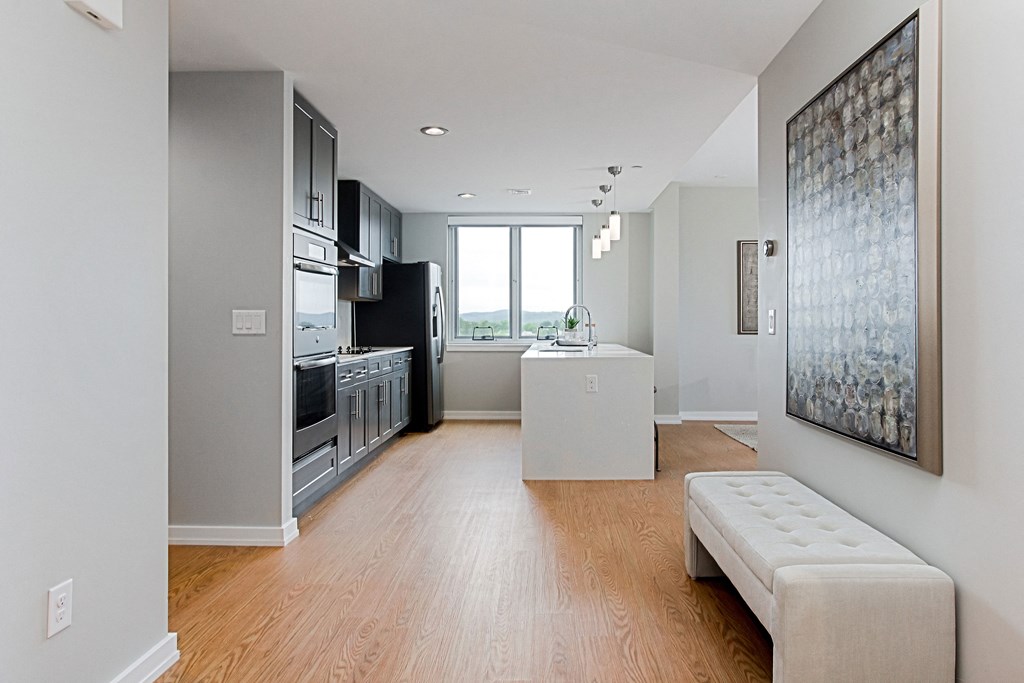 an open kitchen and living room with wood floors and a window