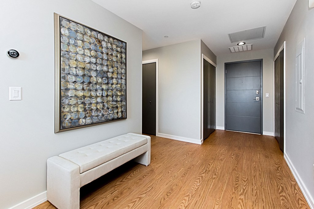 a hallway with a white couch and a painting on the wall and a hallway door