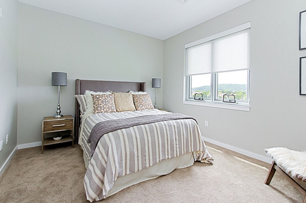 a bedroom with a bed and a window
