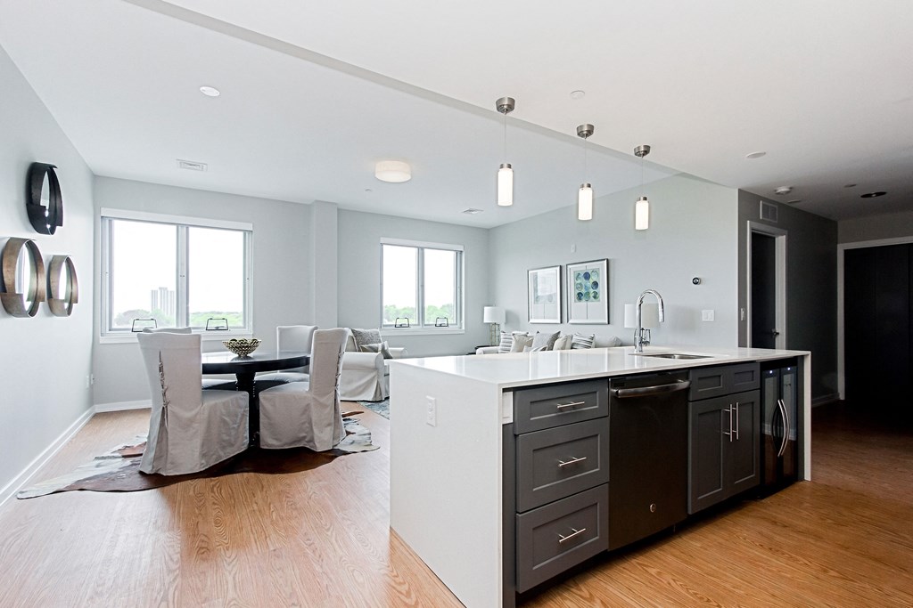 a kitchen with an island and a dining room with a table and chairs