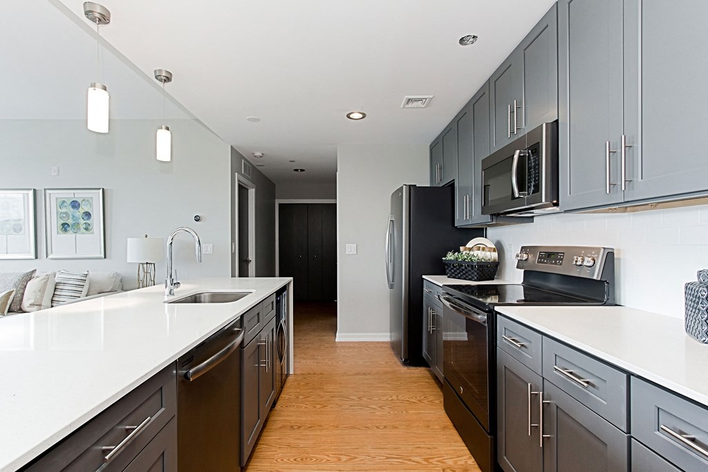 a large kitchen with black appliances and white counters