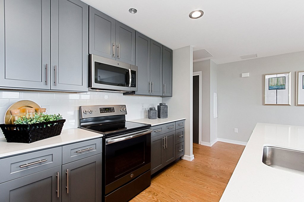 a kitchen with stainless steel appliances and gray cabinets