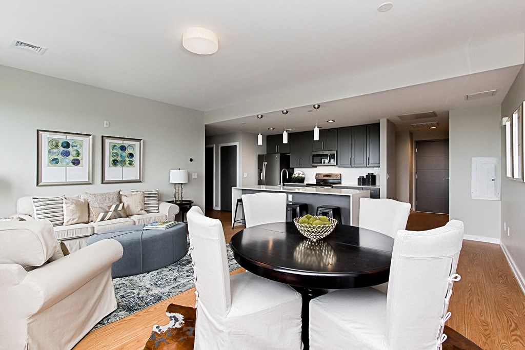 a living room with white chairs and a table