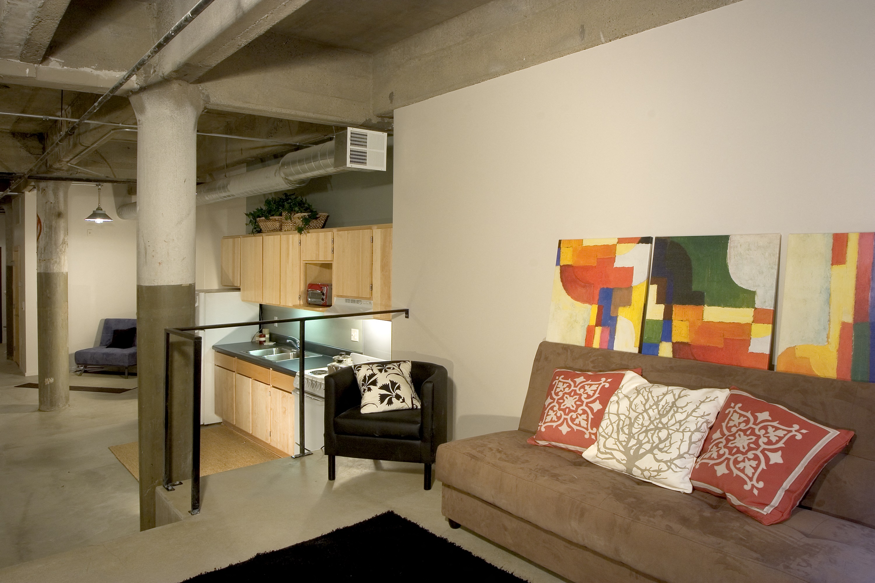 a living room with a couch and a kitchen in a loft