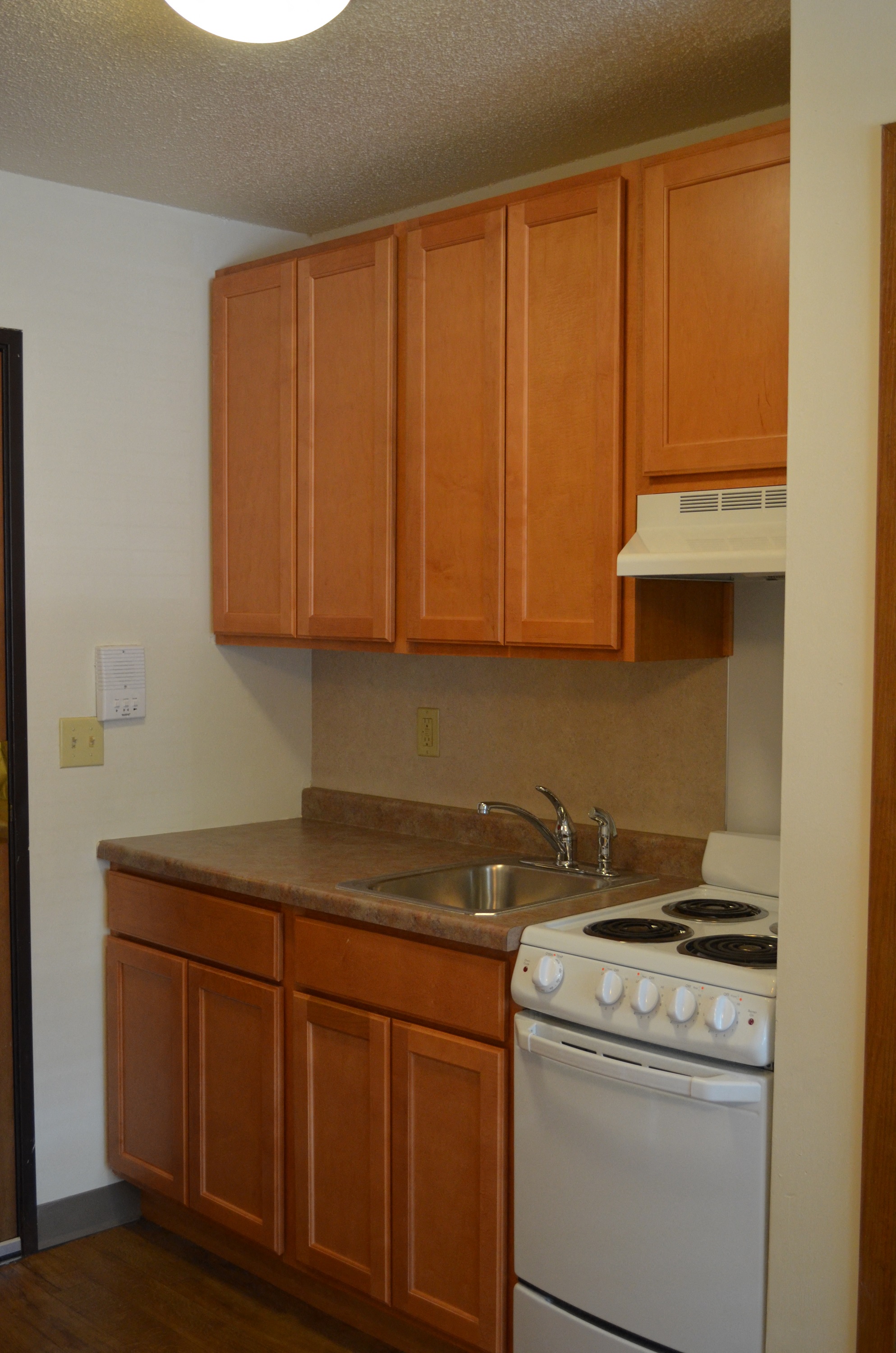 a kitchen with wooden cabinets and a stove and a sink