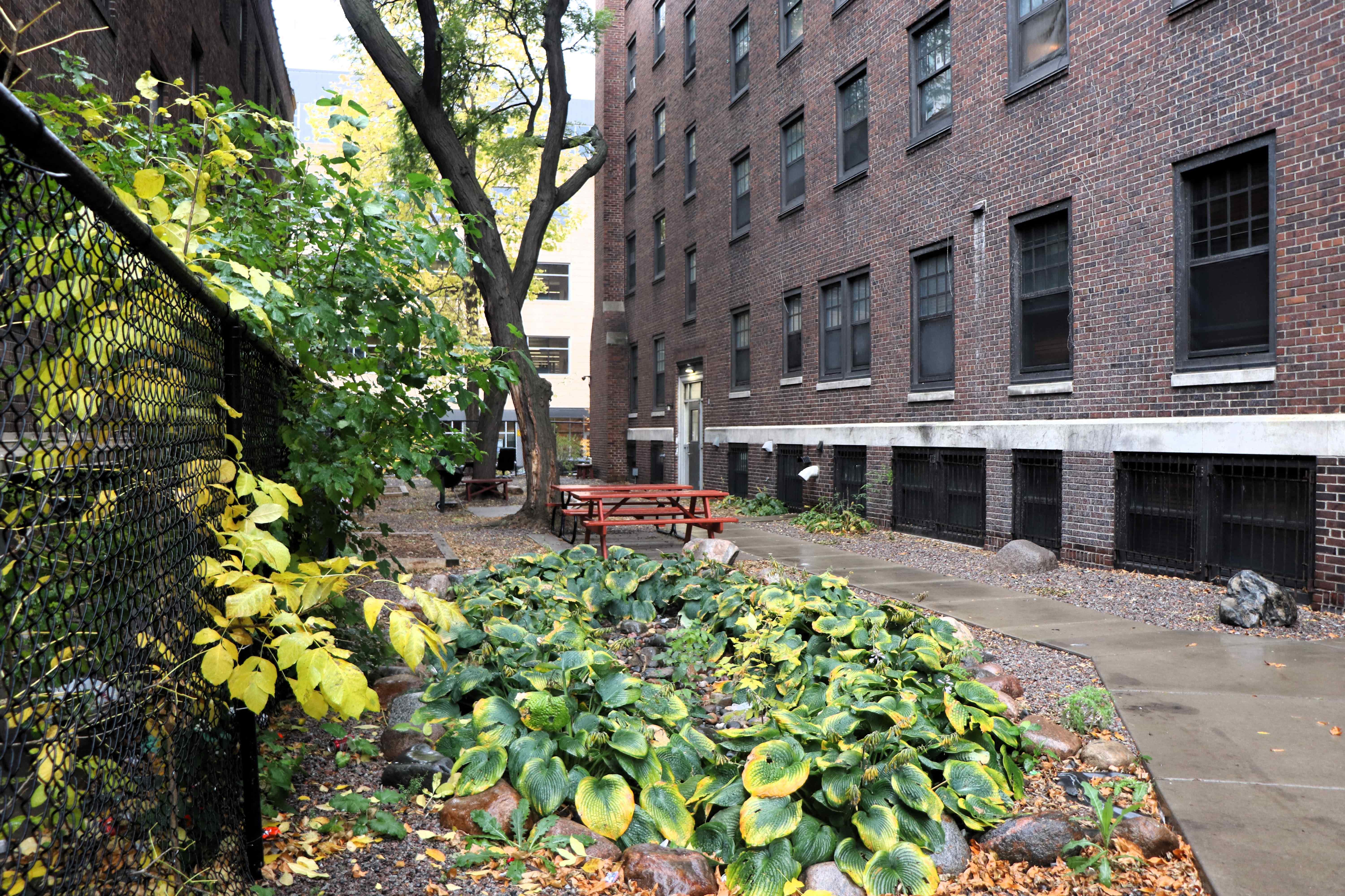 a garden in front of a brick building