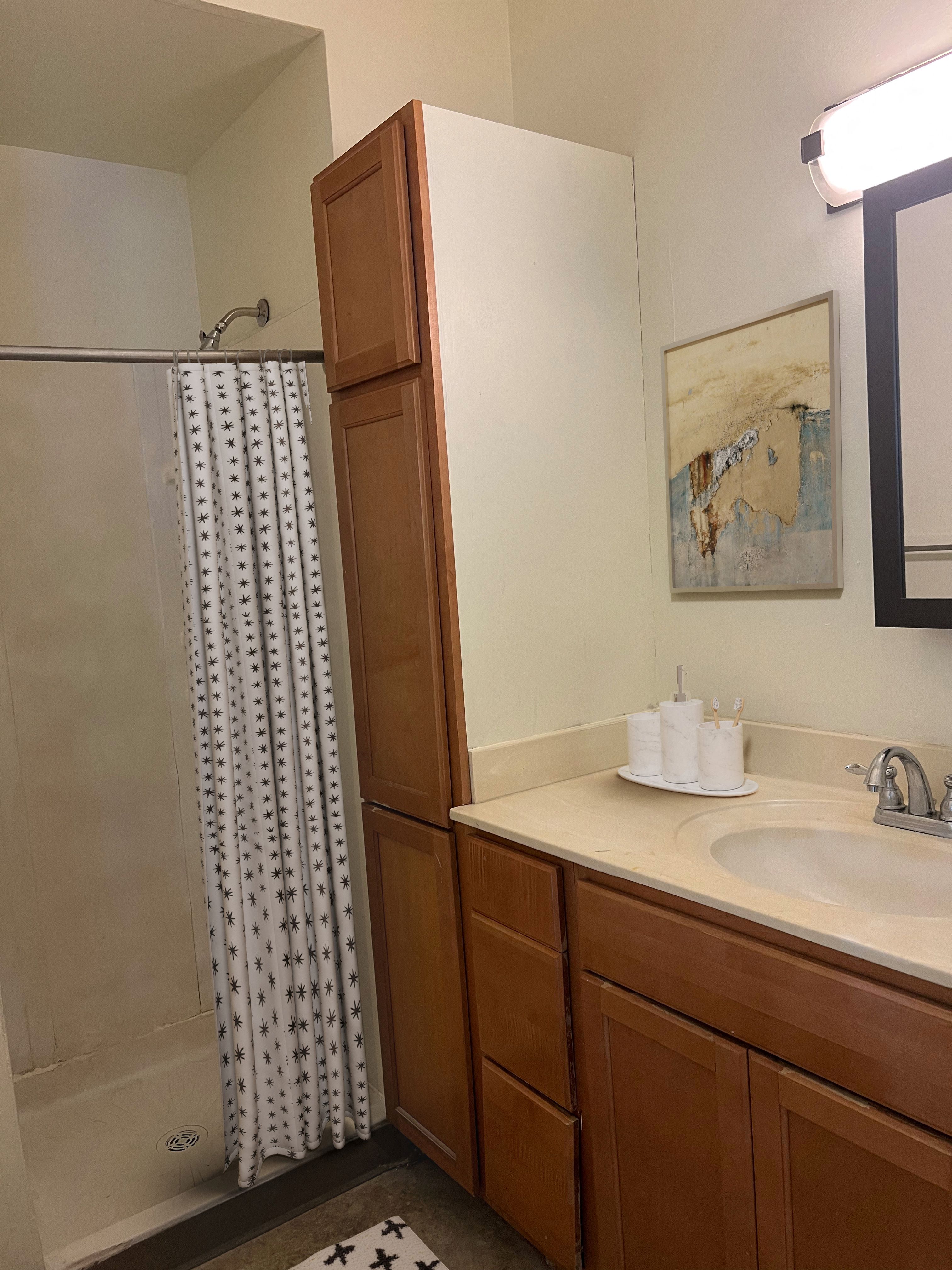 a bathroom with a shower and a sink and a mirror
