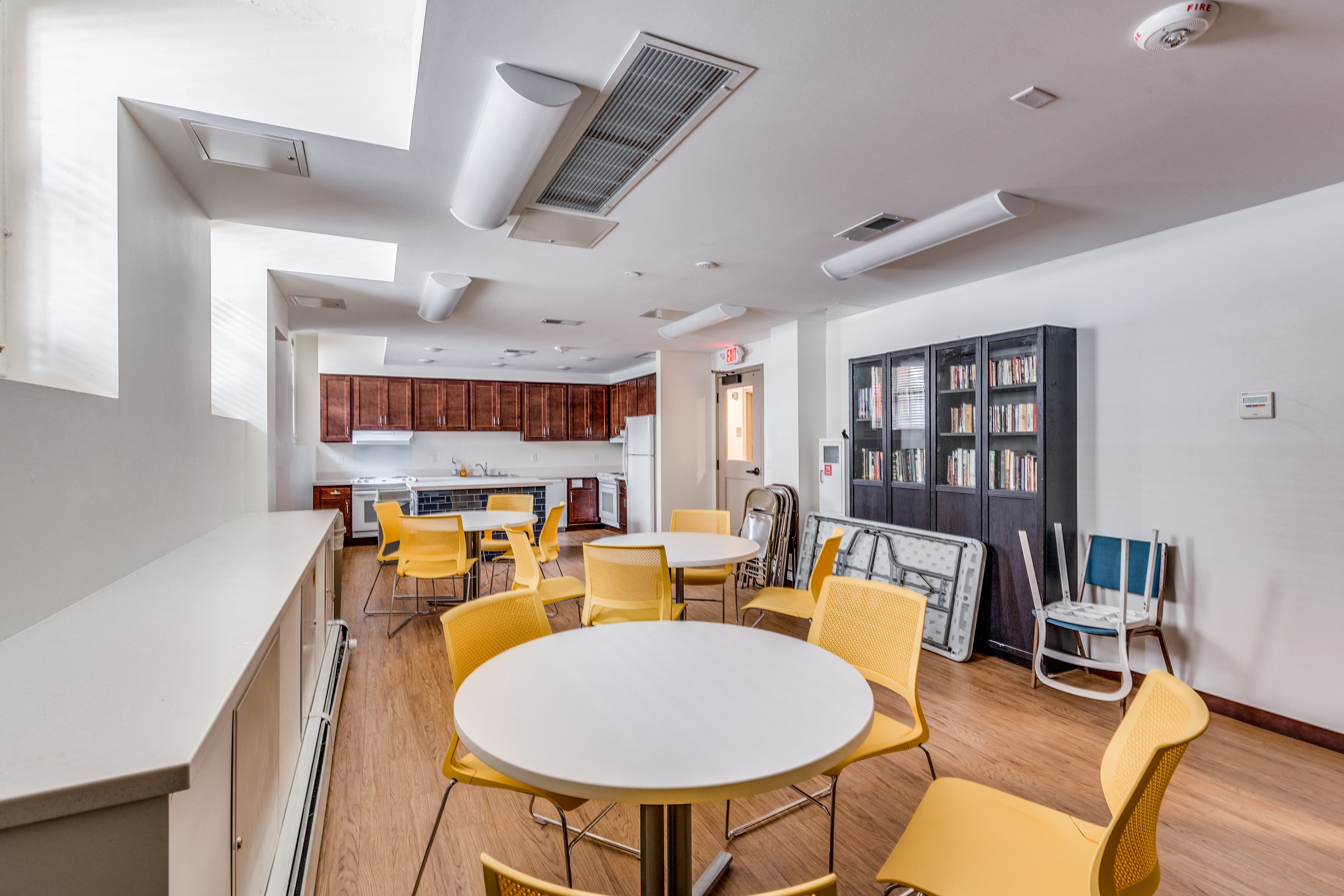 a dining room with tables and chairs and a kitchen