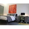 A bedroom with a bed, nightstand and chair.