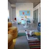 A living room with a couch and a painting on the wall.