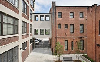 an alleyway between two brick buildings with a courtyard in the middle