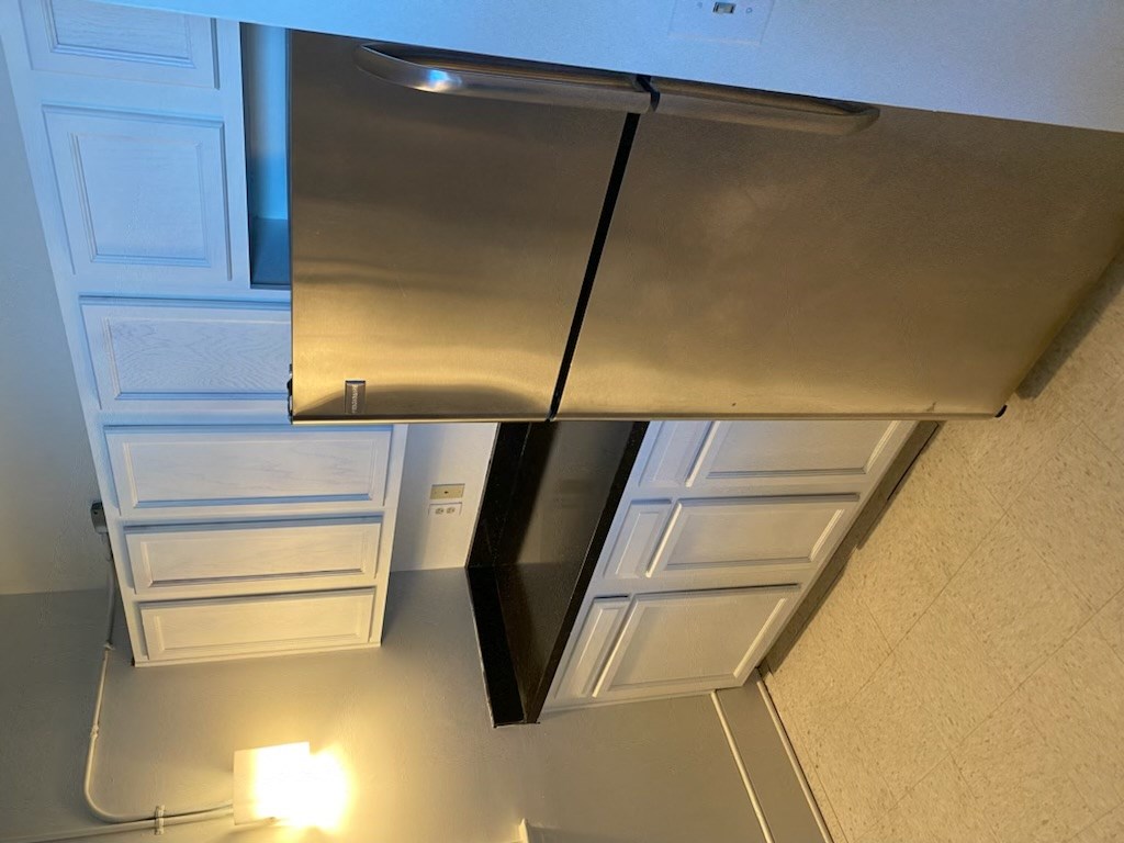 an overhead view of a kitchen with a stainless steel stove and refrigerator