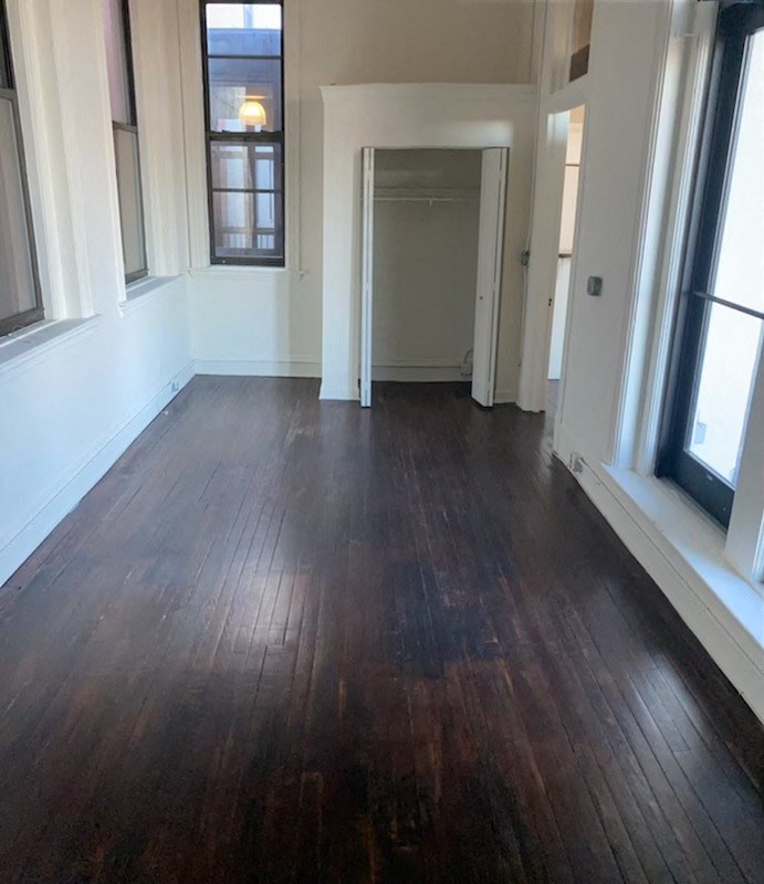 a living room with a hard wood floor and a window