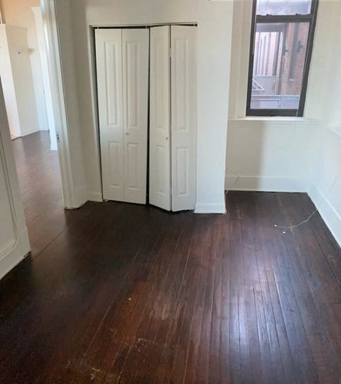 a living room with wood floors and two closet doors