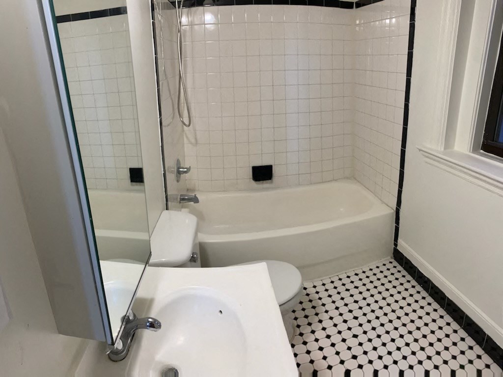 a bathroom with a toilet and a tub and a sink