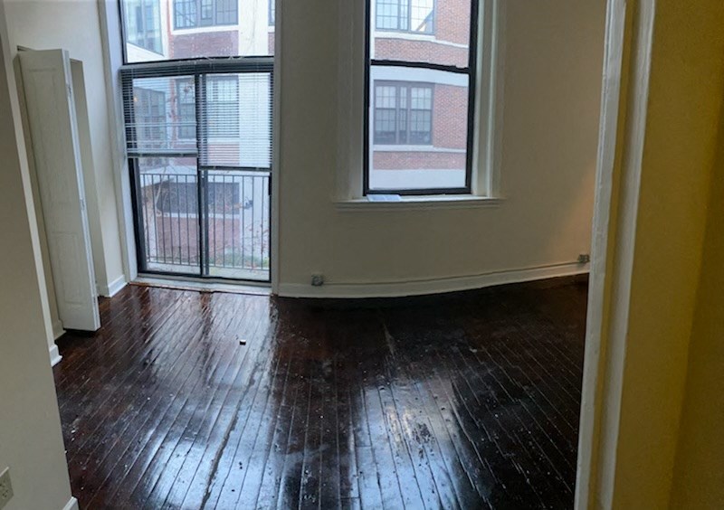 an empty living room with wood floors and a balcony