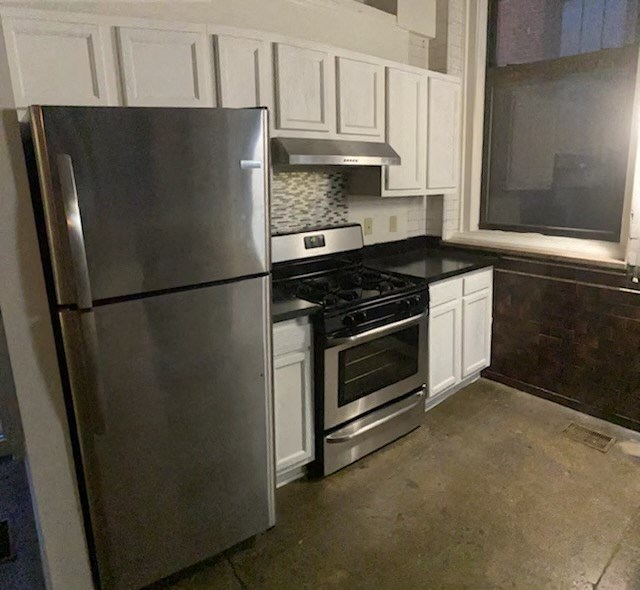 a kitchen with stainless steel appliances and white cabinets