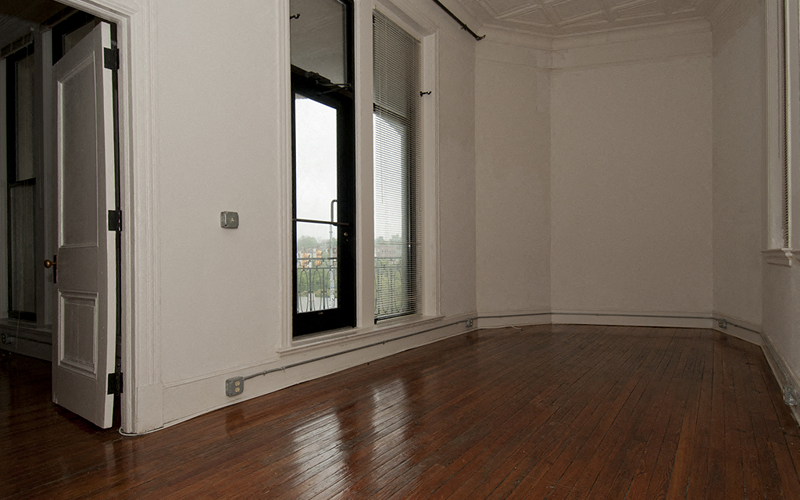an empty living room with wooden floors and a window