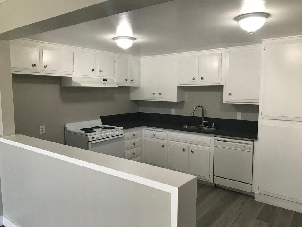 a white kitchen with white cabinets and white appliances