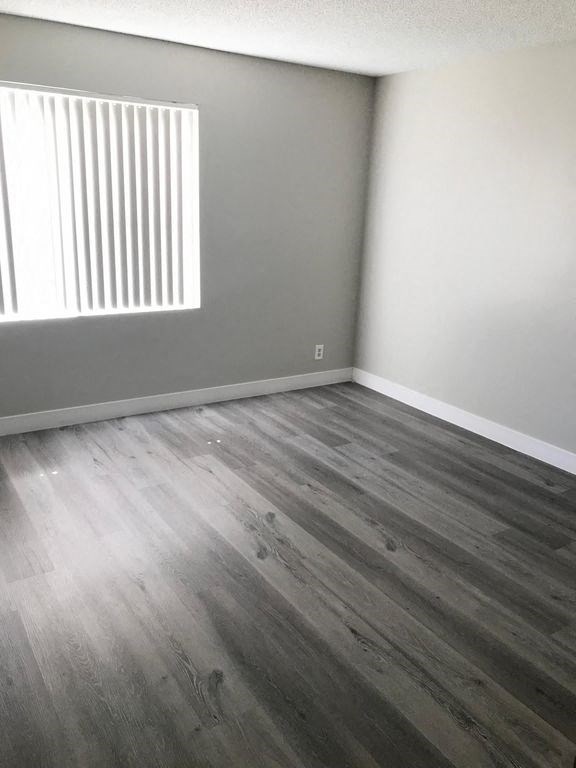 an empty room with wood floors and a window