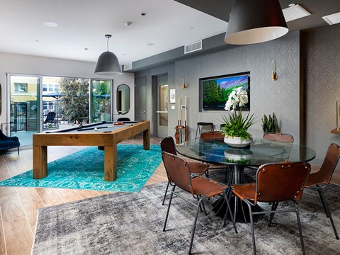 A modern dining room with a glass table and chairs.