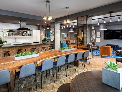 A modern kitchen and dining area with a wooden table and grey chairs.