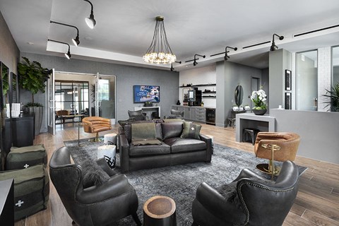 A modern living room with black leather chairs and a grey rug.