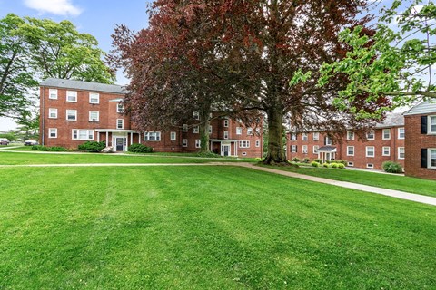 a large green lawn in front of a brick building