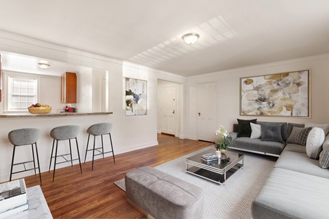 a living room with a couch and a bar with three stools
