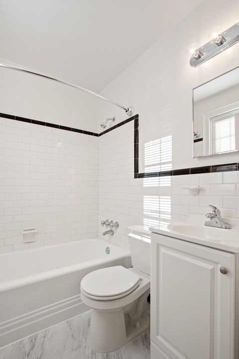 a white bathroom with a toilet and a tub and a sink