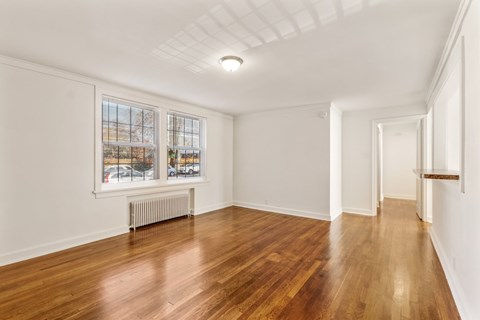 a living room with hardwood floors and a large window