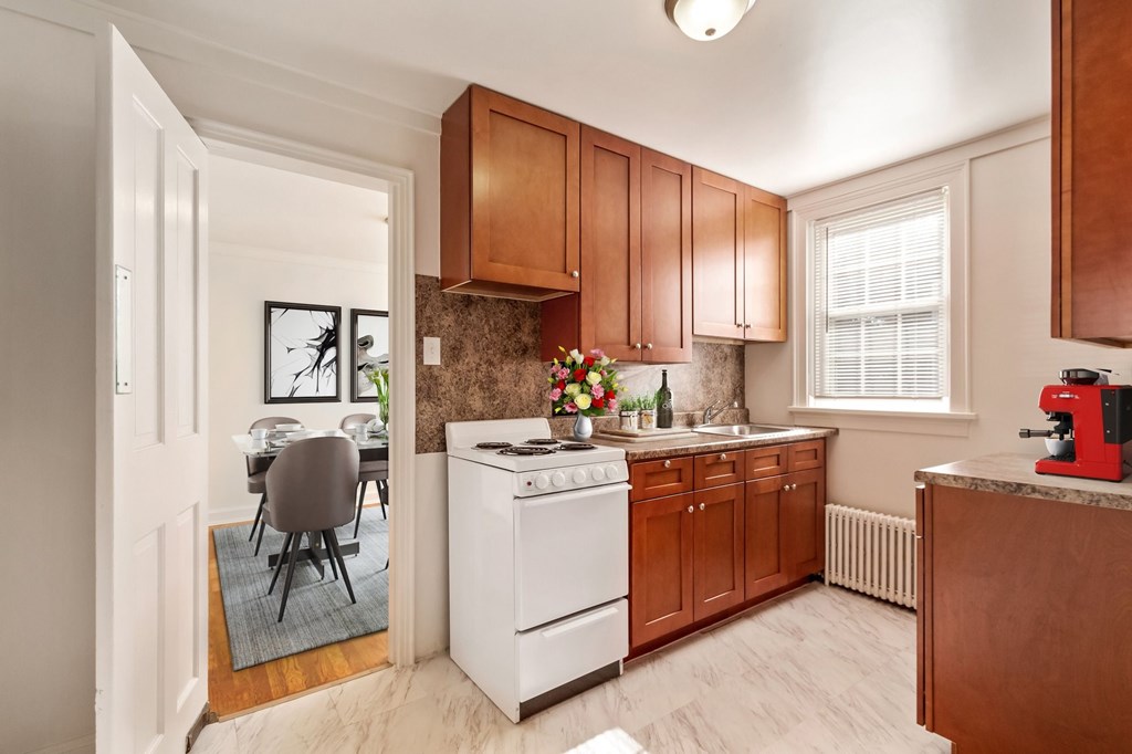a kitchen with wooden cabinets and white appliances and a dining room table