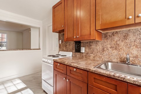 a kitchen with wooden cabinets and white appliances and granite counter tops