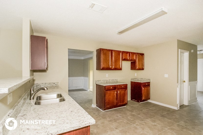 an empty kitchen with a sink and a counter top